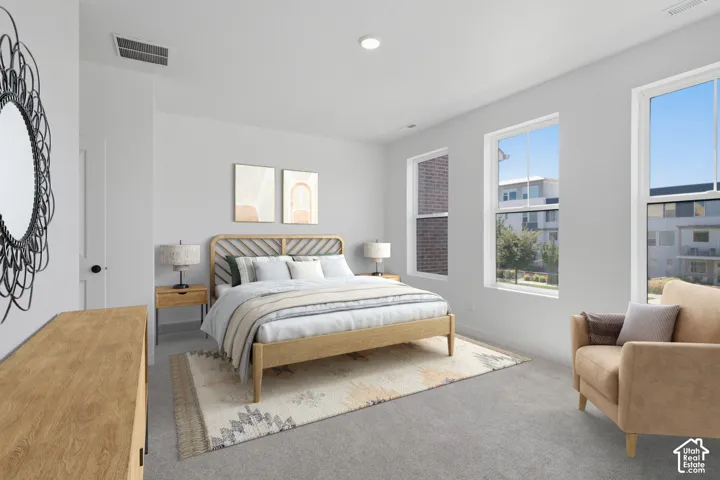 Primary bedroom featuring multiple windows, a recessed ceiling light, and a white interior door with a black handle