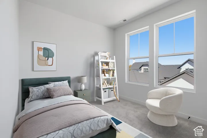 Guest bedroom featuring light gray carpeting two large windows, gray carpet flooring, and white trim