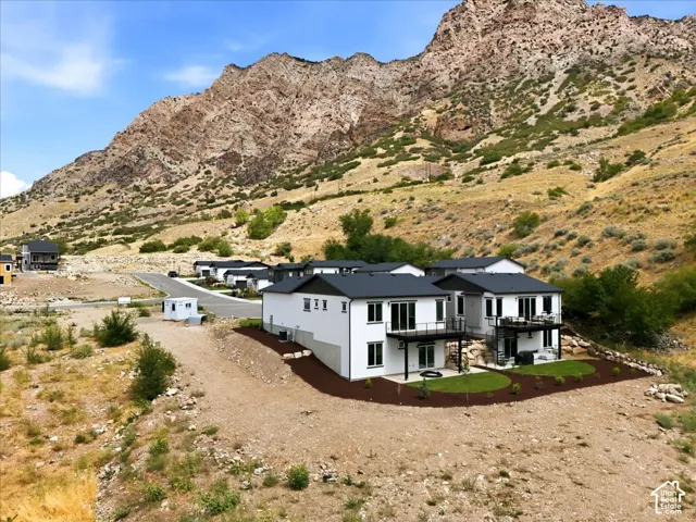 Modern residences featuring dark roofs, light-colored exteriors, and multiple outdoor balconies