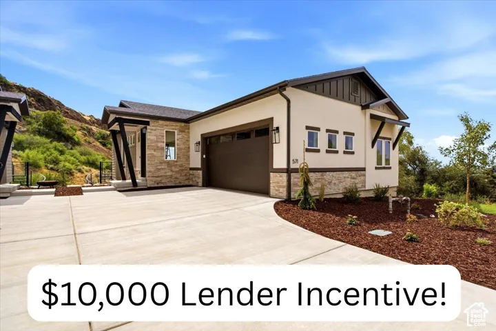 Contemporary residence exterior featuring a stone veneer facade, smooth stucco siding, deep-toned metal garage door, and decorative timber-frame supports