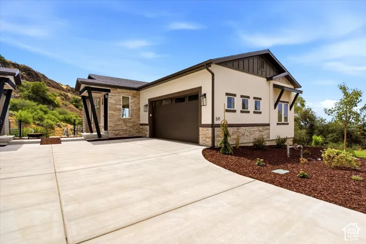 Contemporary stucco exterior with stone accents and a dark brown garage door