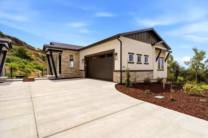 Contemporary stucco exterior with stone accents and a dark brown garage door