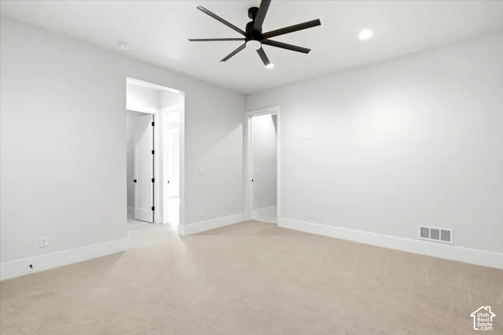 Recessed lighting, ceiling fan with integrated lighting, neutral carpet, and white trim