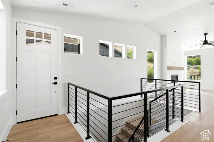Entryway featuring a paneled door with glass inserts, wood-finish flooring, and a modern cable railing system