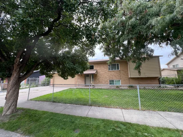 Brick and siding exterior with a chain-link fence