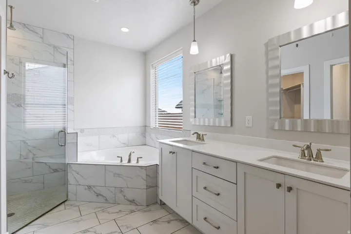 Dual vanity with integrated sinks, brushed nickel fixtures, and white cabinetry