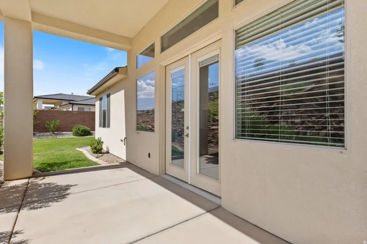 Covered patio with concrete flooring, stucco exterior, and glass French doors