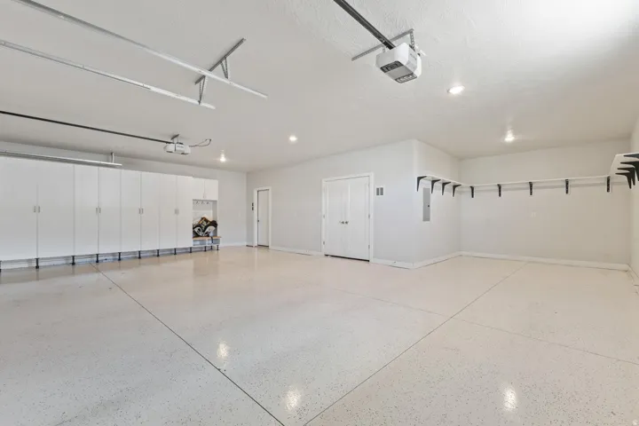 Epoxy finished flooring, built-in storage cabinetry, recessed lighting, double panel interior doors, and wall-mounted shelving