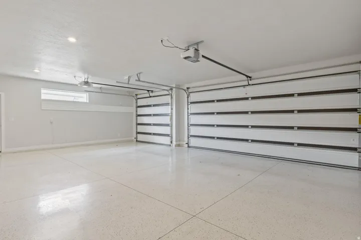 Two-car garage featuring automatic openers, epoxy flooring, and recessed lighting