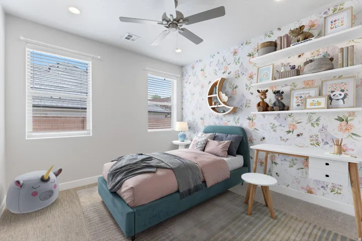 Recessed ceiling lighting, ceiling fan, two windows with blinds, built-in shelving, and accent wall with floral-patterned wallpaper