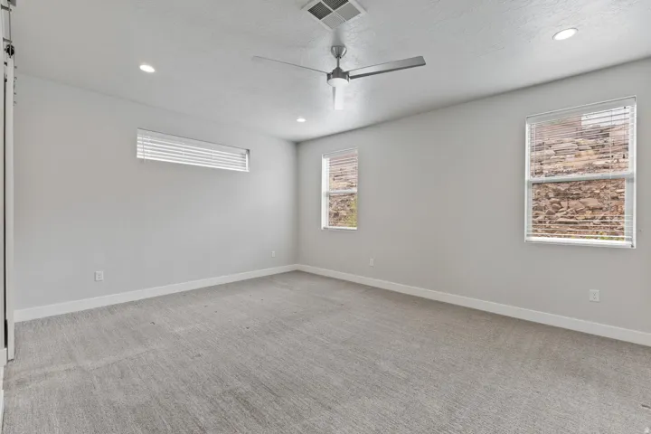 Recessed lighting, ceiling fan, and multiple windows with blinds