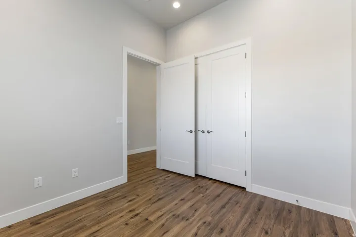 Wood-finish flooring, recessed lighting, and white interior doors