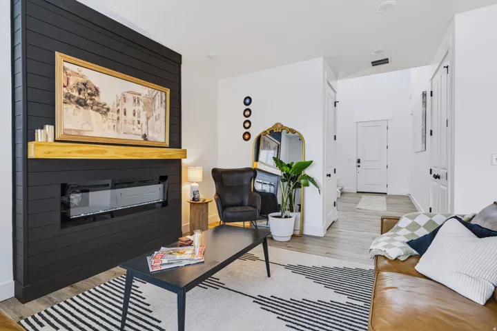 Electric fireplace with a black shiplap surround and a wood mantle