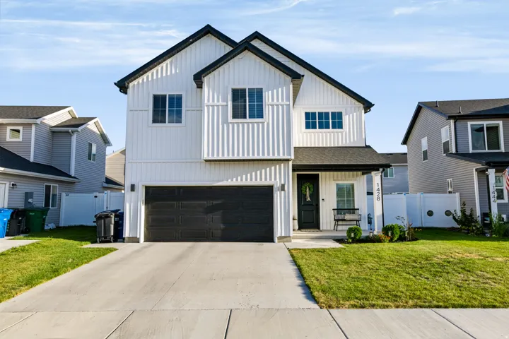 Two-story residence featuring white vertical siding and black trim