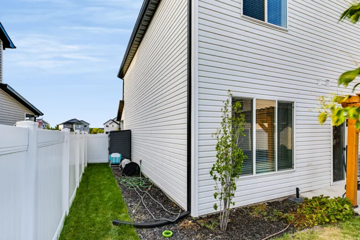 White vinyl siding exterior with an adjacent privacy fence