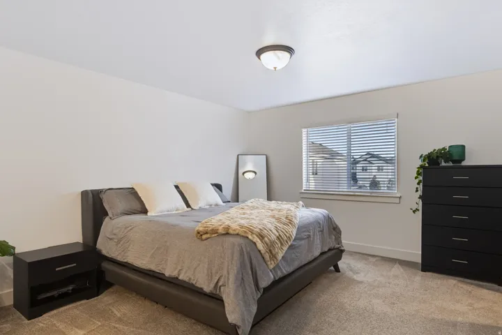 Neutral paint colors, carpet flooring, a single window with blinds, and a flush mount ceiling light fixture