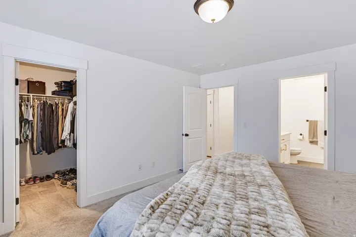 Recessed closet with a built-in hanging rack, white interior doors, and a ceiling-mounted light fixture