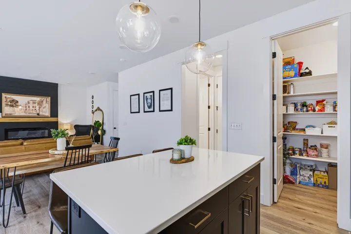 Kitchen island with a white countertop and dark cabinetry