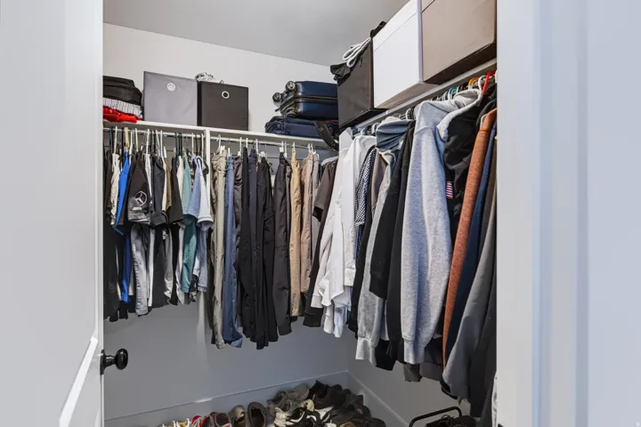 Closet featuring a built-in shelving system, hanging rods, and an open layout