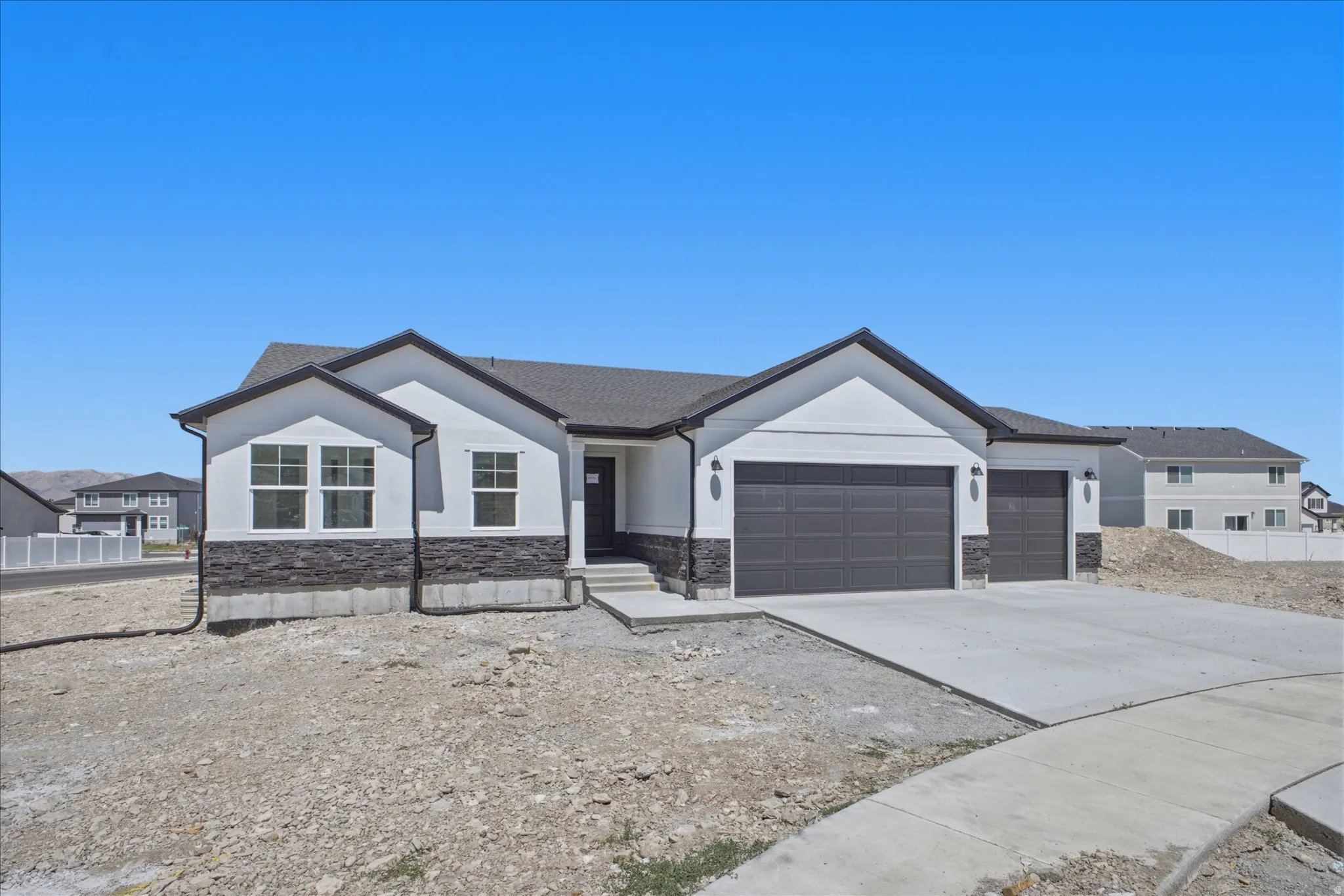 Contemporary architectural style with a white stucco finish and dark stone accents