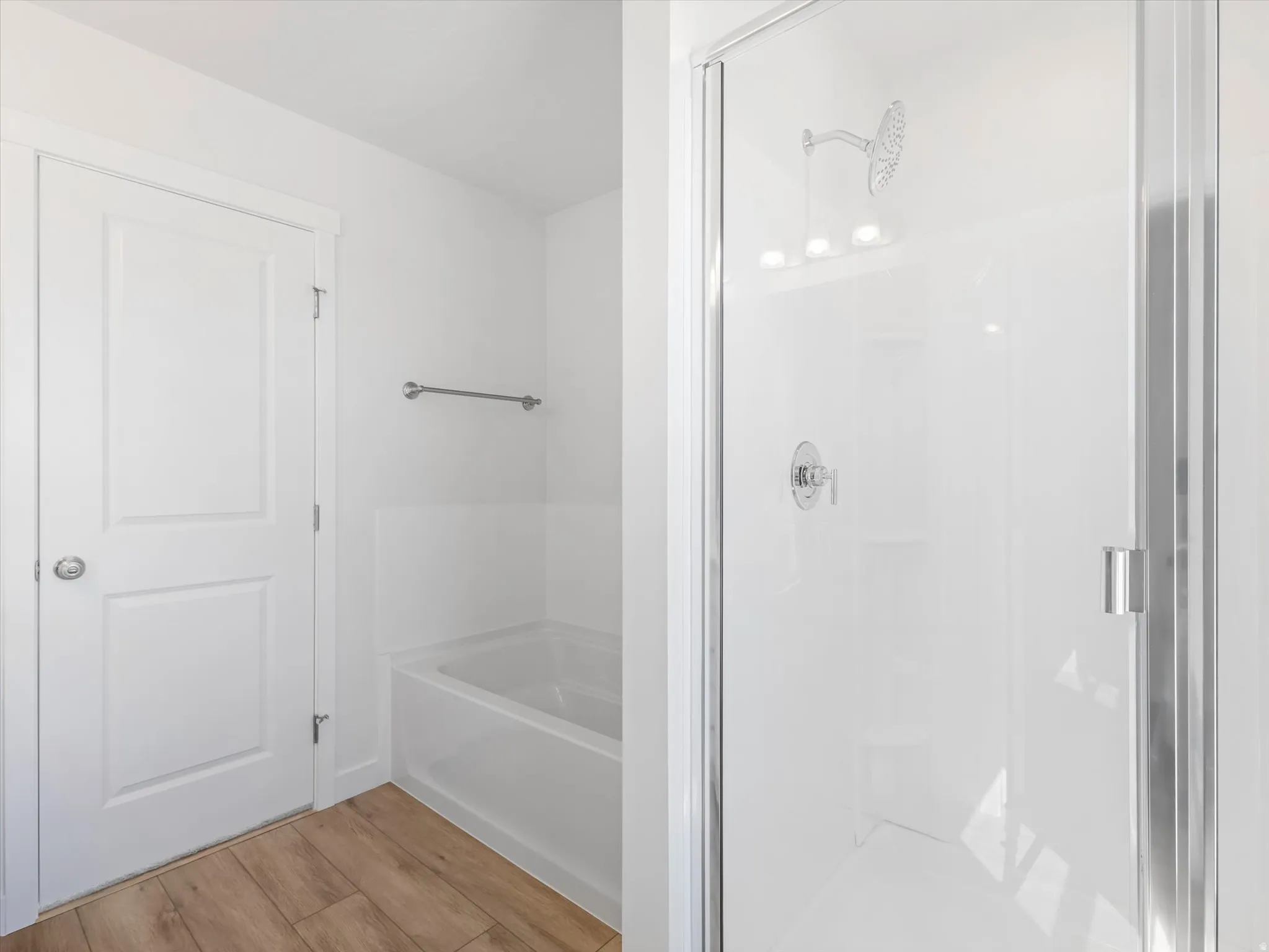 Walk-in shower with clear glass enclosure, chrome fixtures, and built-in shelving