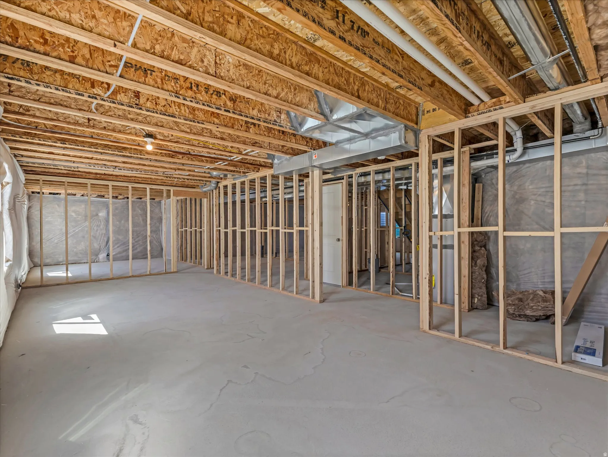 Unfinished basement with concrete flooring and exposed ceiling joists