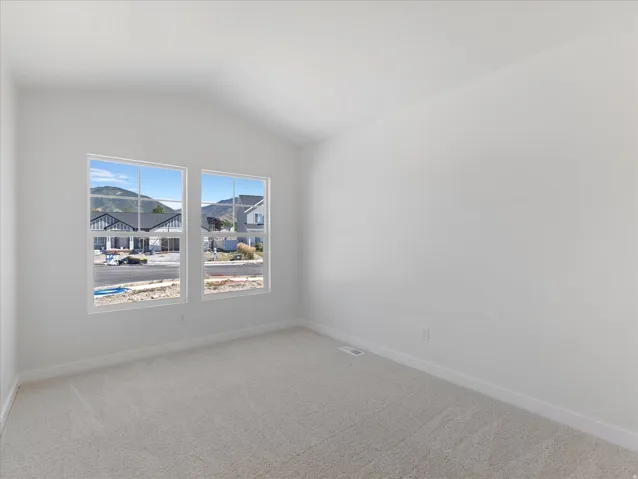 Vaulted ceilings, light-colored carpeting, and dual windows