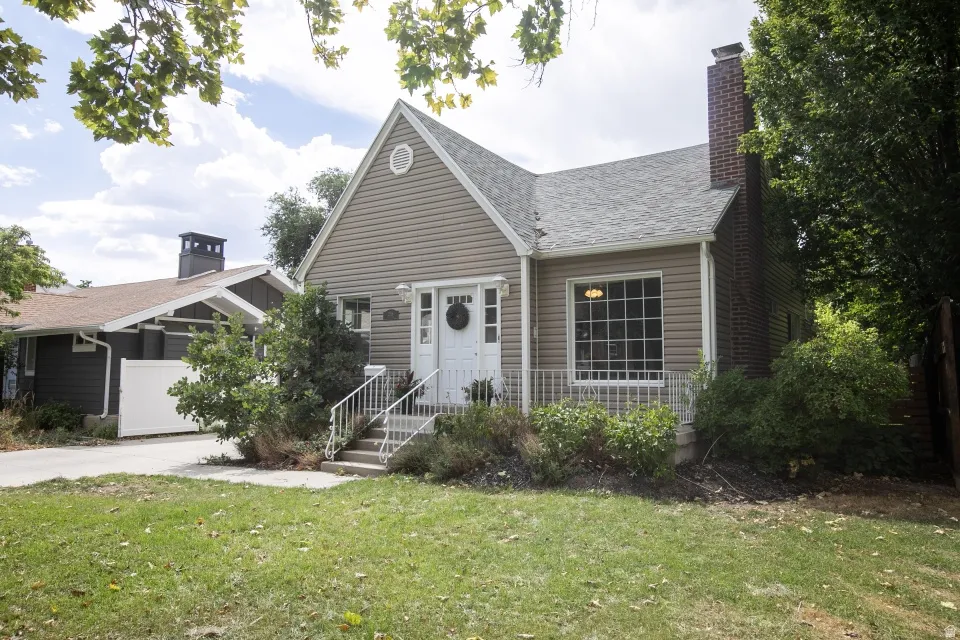 Exterior featuring horizontal siding, a prominent brick chimney, and a gabled roofline