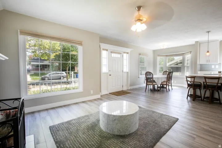 Expansive living area with wood-finish flooring, large picture window, and recessed bay window