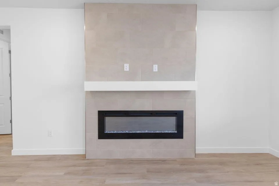 Floor-to-ceiling tile fireplace surround with a linear electric fireplace and a floating mantel