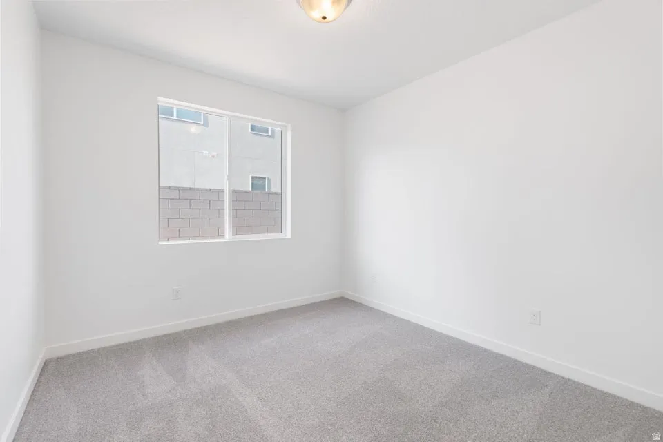 Recessed window, neutral wall paint, light gray carpeting, and flush mount ceiling fixture