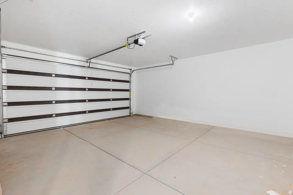 Spacious garage with a sectional overhead door and concrete flooring