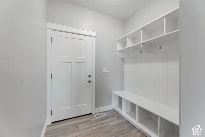Built-in storage solutions with open shelving, integrated bench seating, and wall-mounted hooks