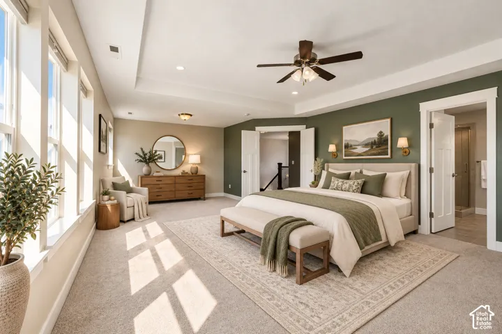 Spacious room featuring a tray ceiling, expansive multi-pane windows, recessed lighting, and a ceiling fan with integrated light fixture