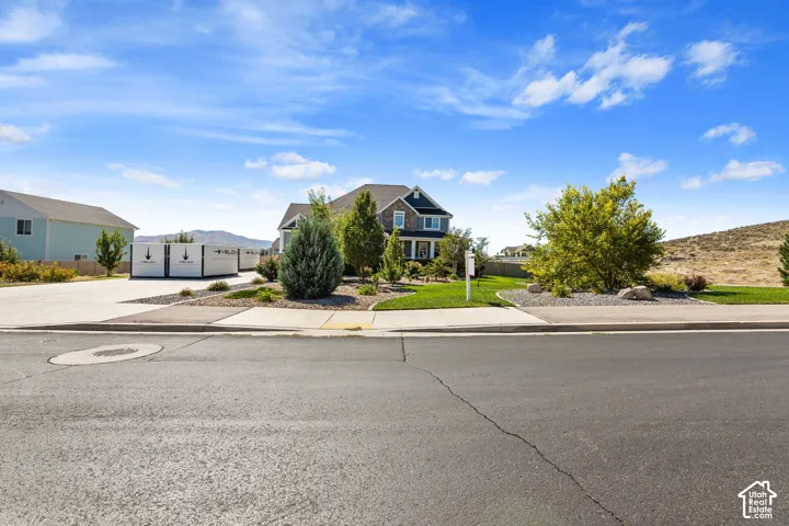 Two-story residence with a stone and siding exterior, front landscaping, and a concrete driveway
