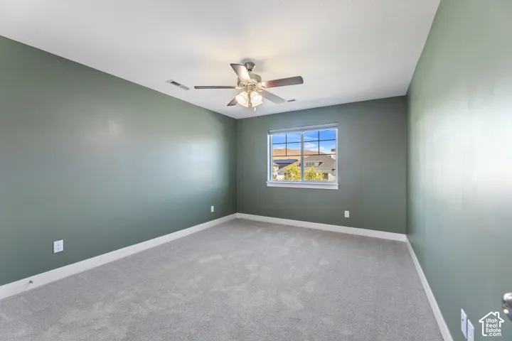 Recessed window with white trim, light-toned carpet, and a ceiling fan with integrated lighting