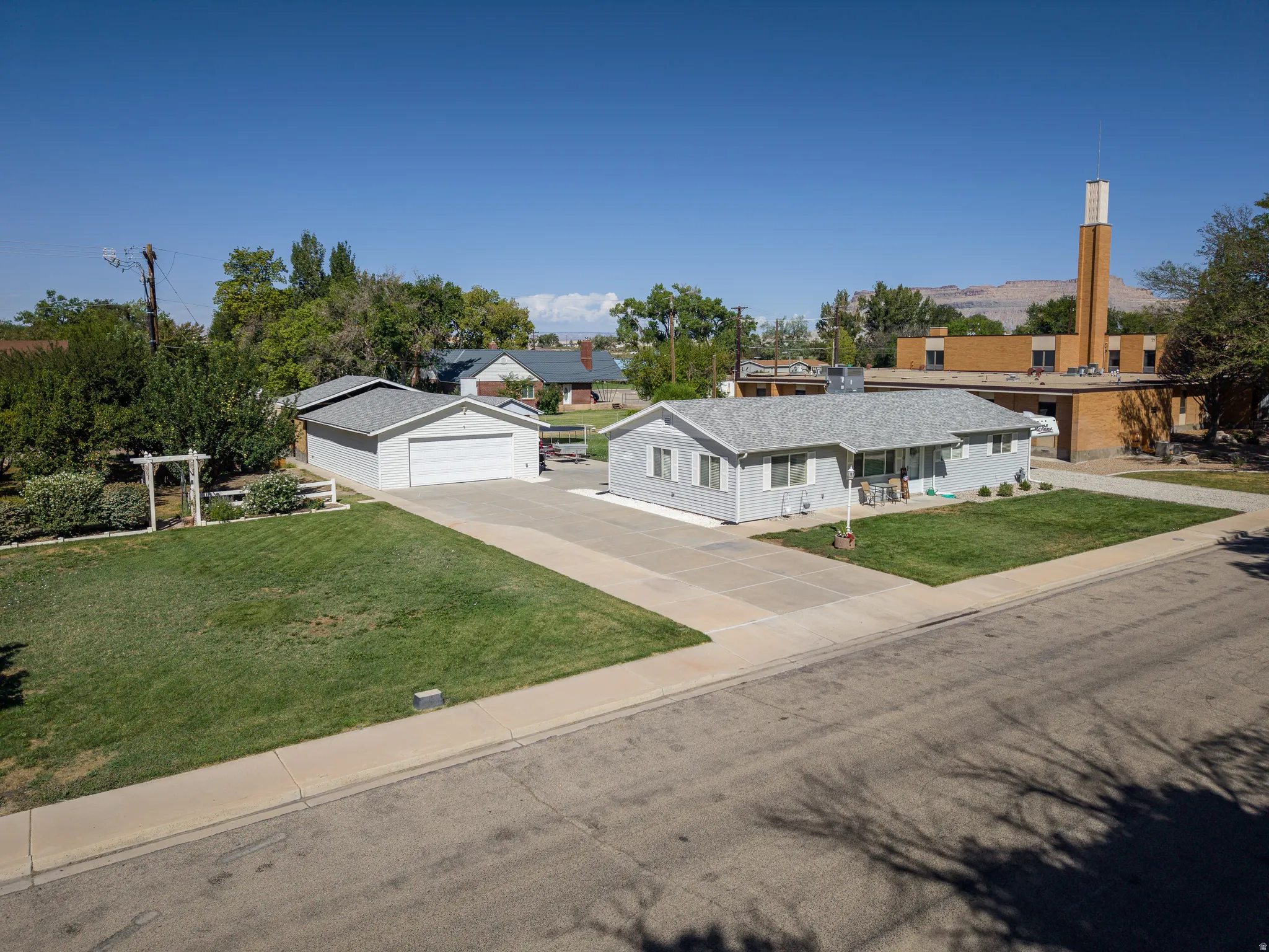 Single-story residence featuring a gray exterior, attached covered porch, and a two-car garage