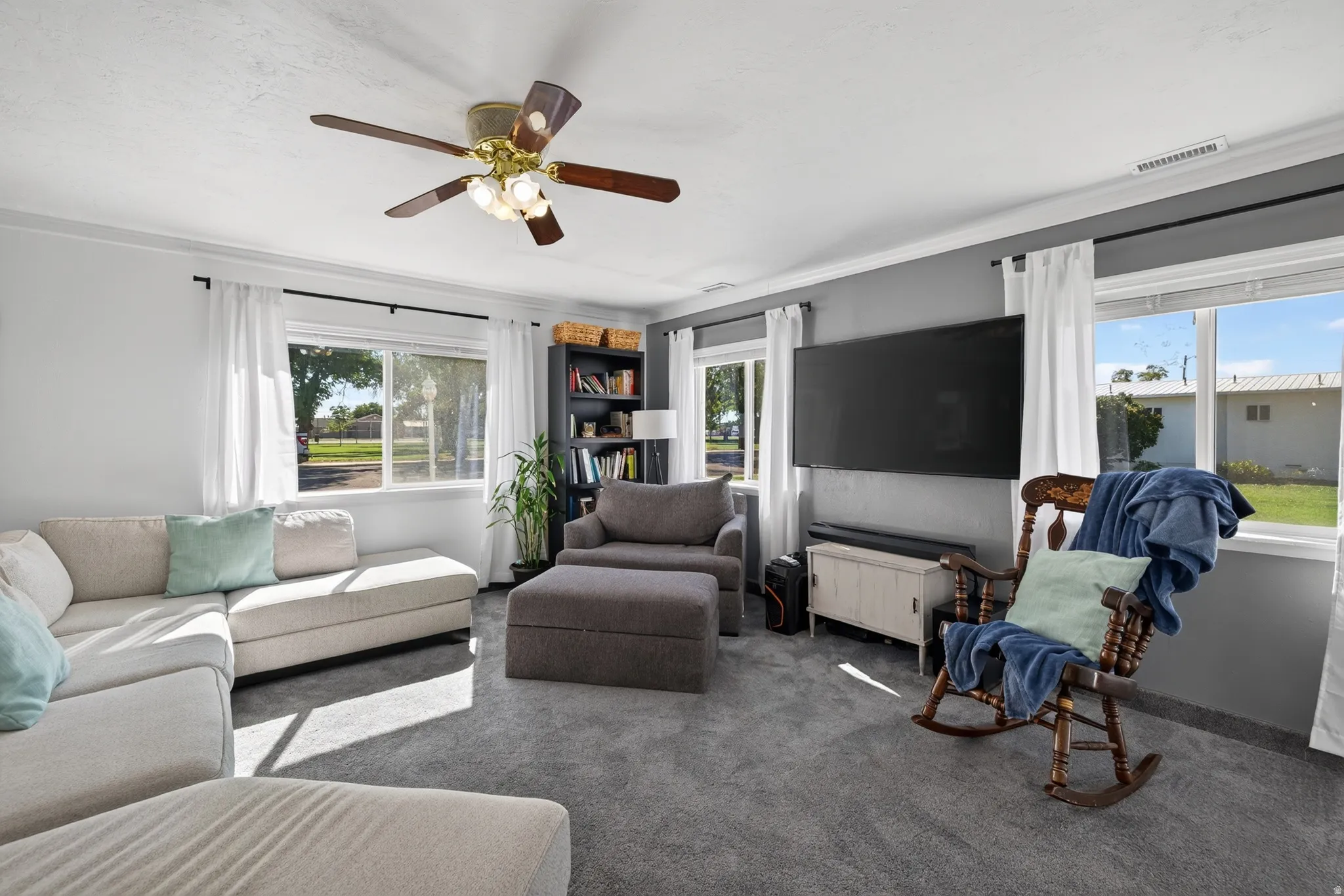 Recessed lighting with a ceiling fan, multiple windows with white trim, and crown molding