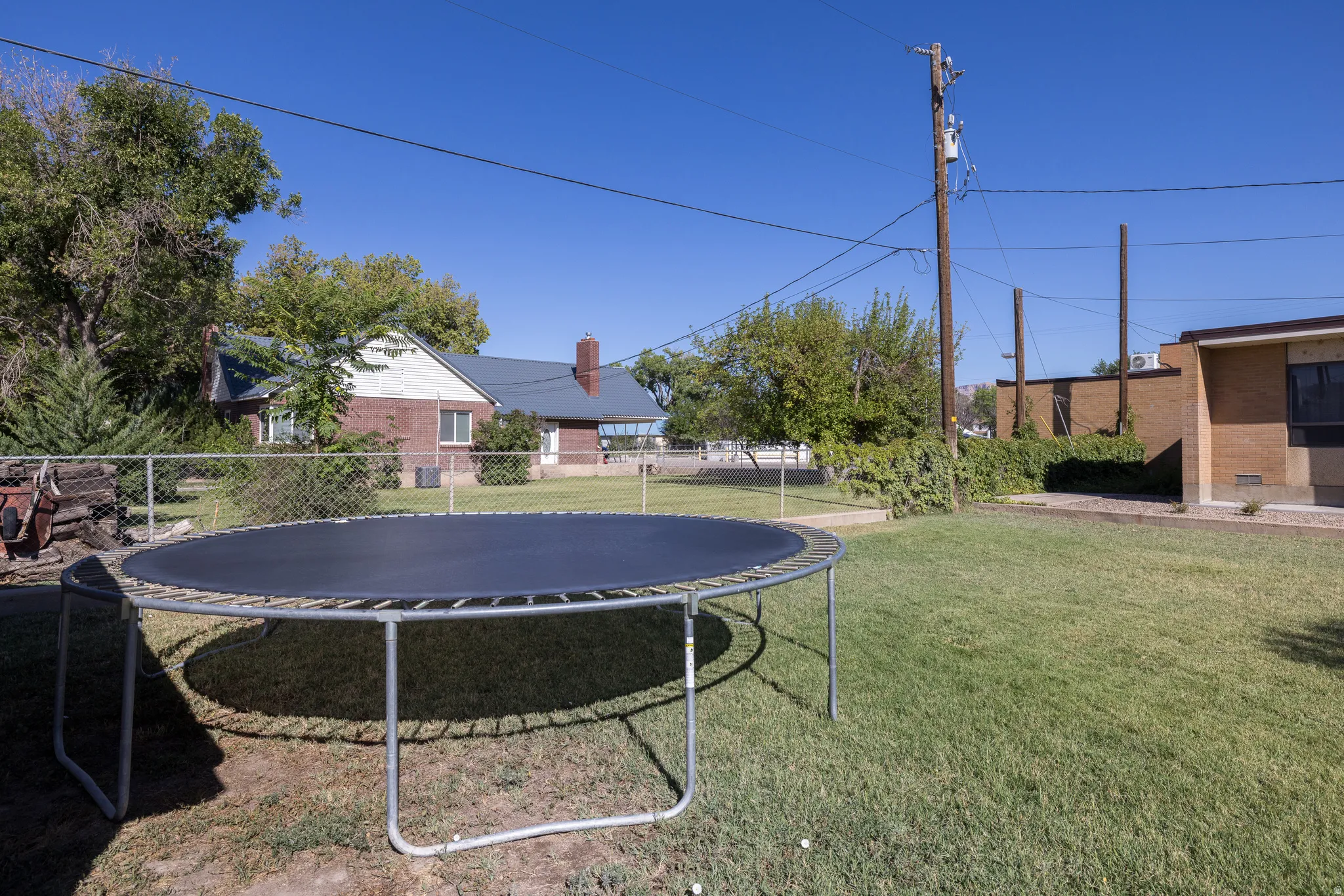 Expansive grass backyard bordered by chain-link fencing