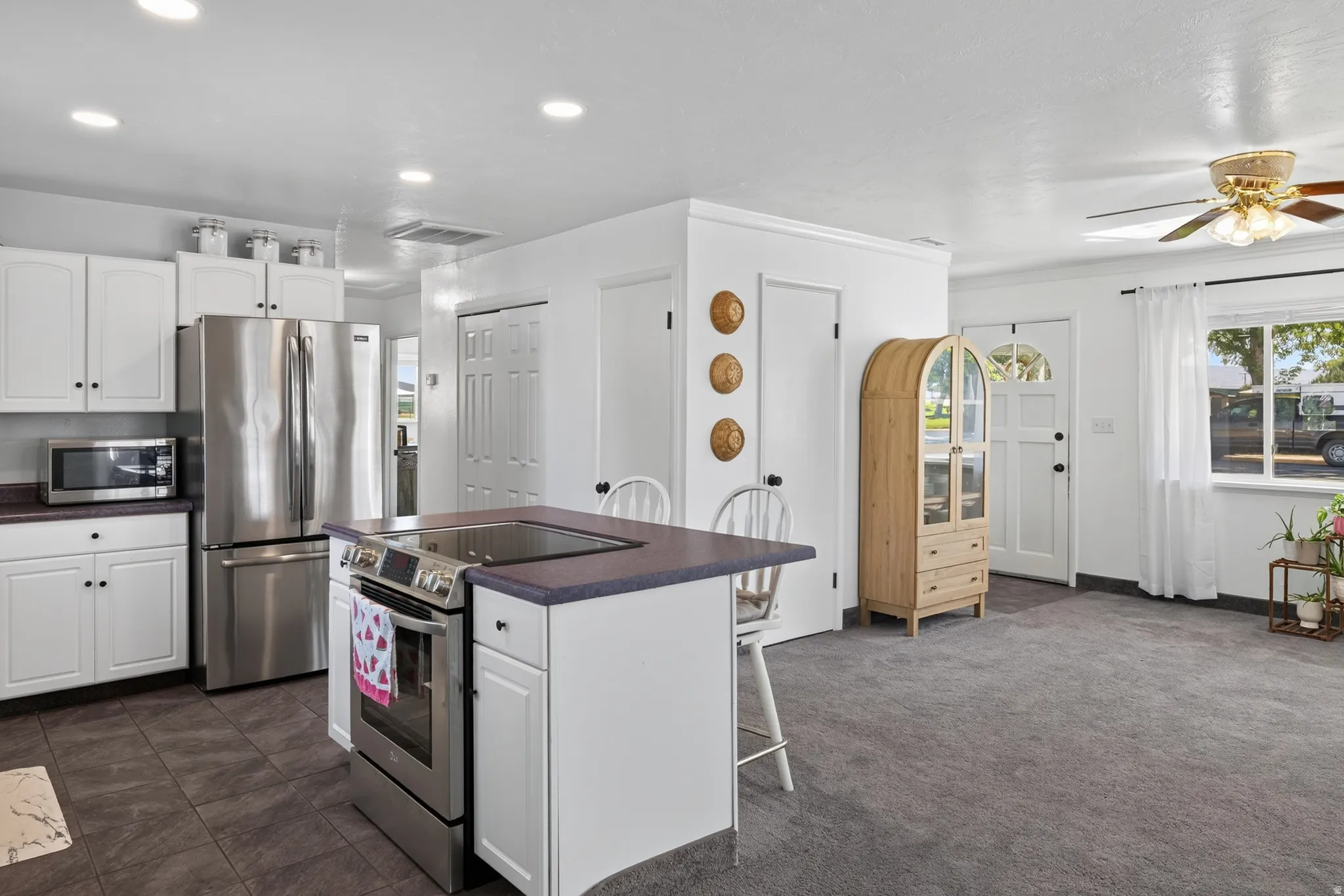 Kitchen featuring white cabinetry, stainless steel appliances, a center island with cooktop, and recessed lighting