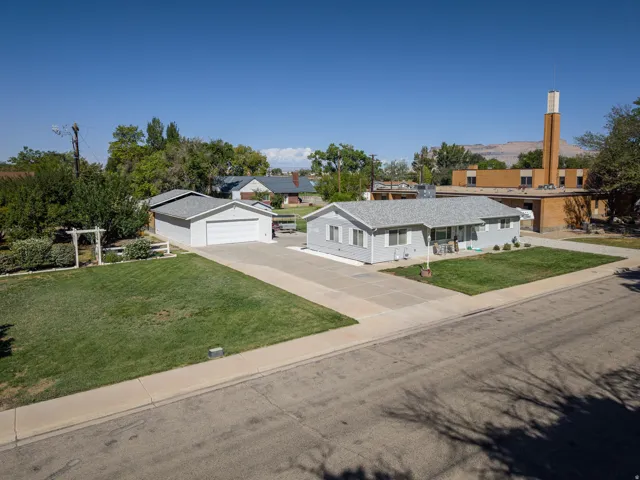 Single-story residence featuring a gray exterior, attached covered porch, and a two-car garage