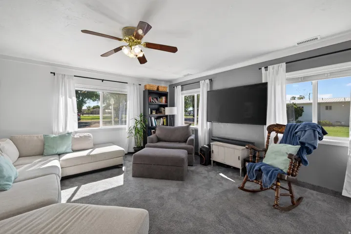 Recessed lighting with a ceiling fan, multiple windows with white trim, and crown molding