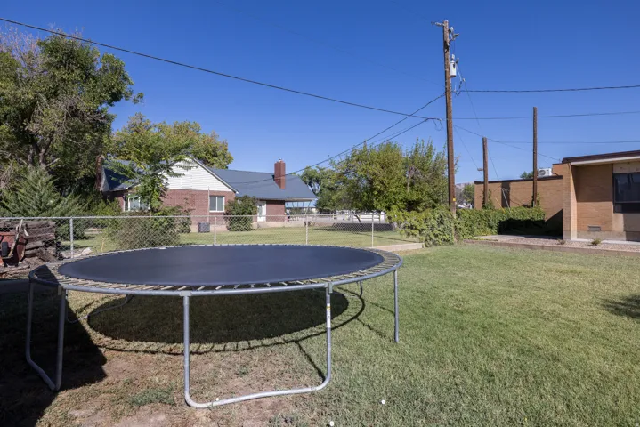 Expansive grass backyard bordered by chain-link fencing