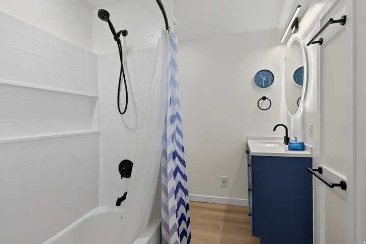 White tiled shower with a built-in niche and matte black fixtures