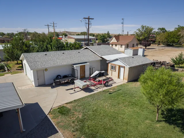 Attached two-car garage, separate detached shed, paved driveway, carport, and manicured lawn