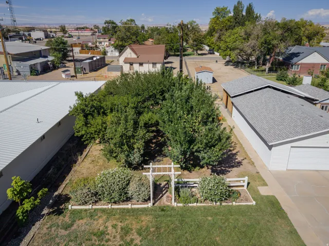 Manicured lawn, established landscaping, and a white trellis entrance