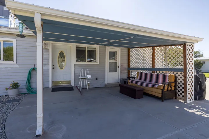 Covered concrete patio with lattice privacy screens and direct exterior access