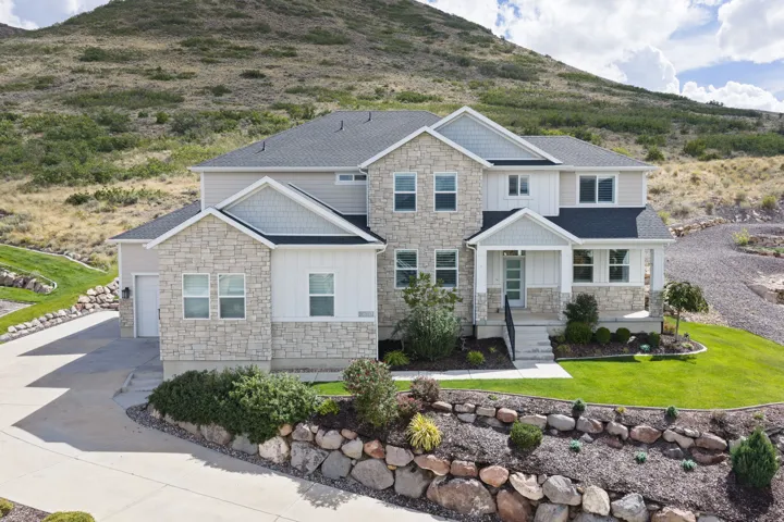 Stone and siding exterior with dark shingle roof