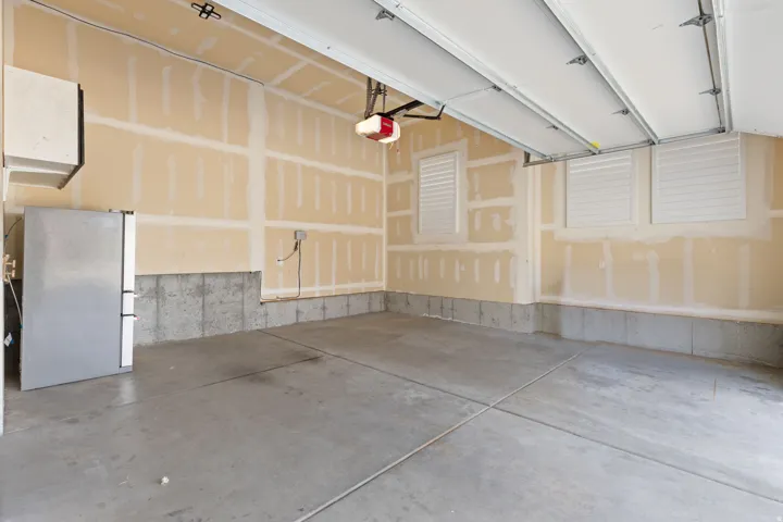 Concrete flooring with expansion joints, unfinished drywall, and a concrete foundation wall