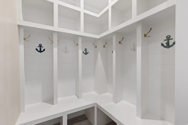 Built-in white storage lockers with upper cubbies, shiplap back paneling, and integrated bench seating with lower compartments